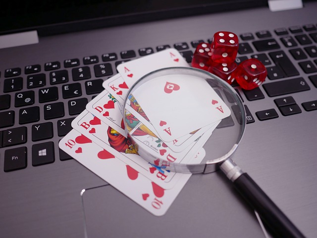 Cards, Dice and a Magnifying Glass on a Laptop